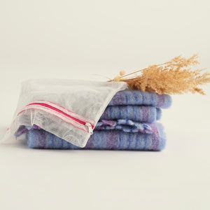Ooia Washbag aus feinmaschigem Netzmaterial – ideal zum Waschen von Periodenunterwäsche in der Maschine. ooia Washbag liegt auf Handtüchern.