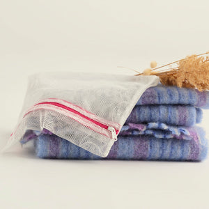 Ooia Washbag aus feinmaschigem Netzmaterial – ideal zum Waschen von Periodenunterwäsche in der Maschine. ooia Washbag liegt auf Handtüchern.