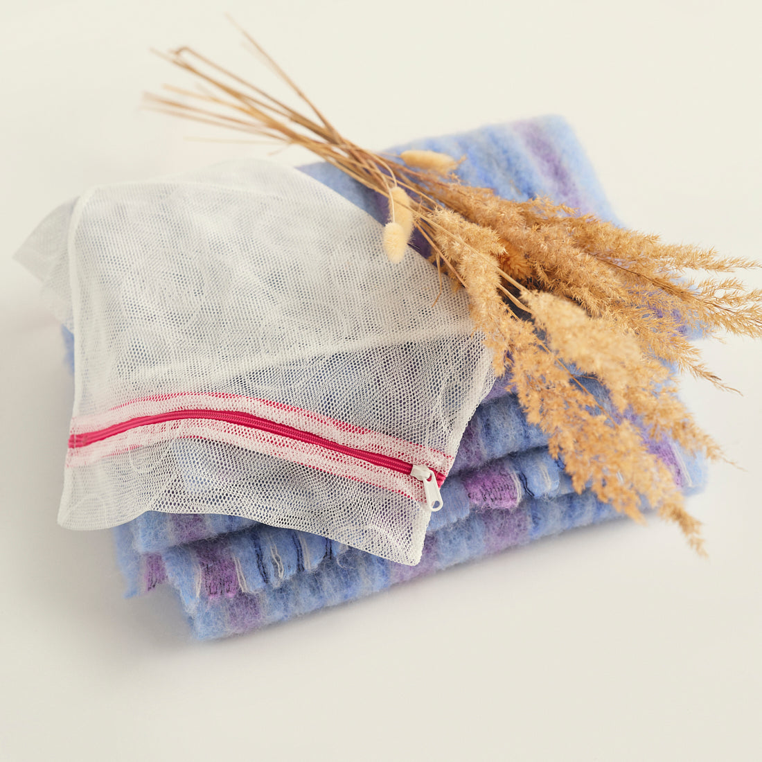 Ooia Washbag aus feinmaschigem Netzmaterial – ideal zum Waschen von Periodenunterwäsche in der Maschine. ooia Washbag liegt auf Handtüchern.