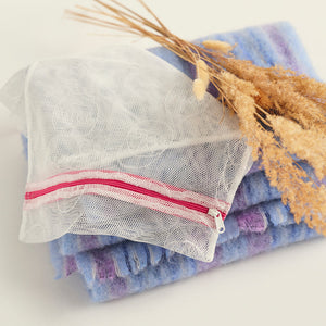 Ooia Washbag aus feinmaschigem Netzmaterial – ideal zum Waschen von Periodenunterwäsche in der Maschine. ooia Washbag liegt auf Handtüchern.