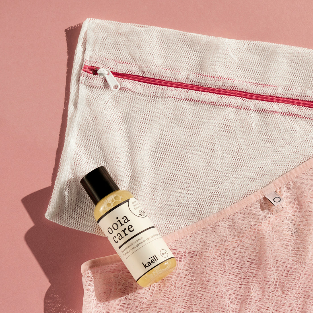 Ooia Washbag aus feinmaschigem Netzmaterial – ideal zum Waschen von Periodenunterwäsche in der Maschine. Mit ooia care Waschlotion und einer Periodenunterhose im Anschnitt.