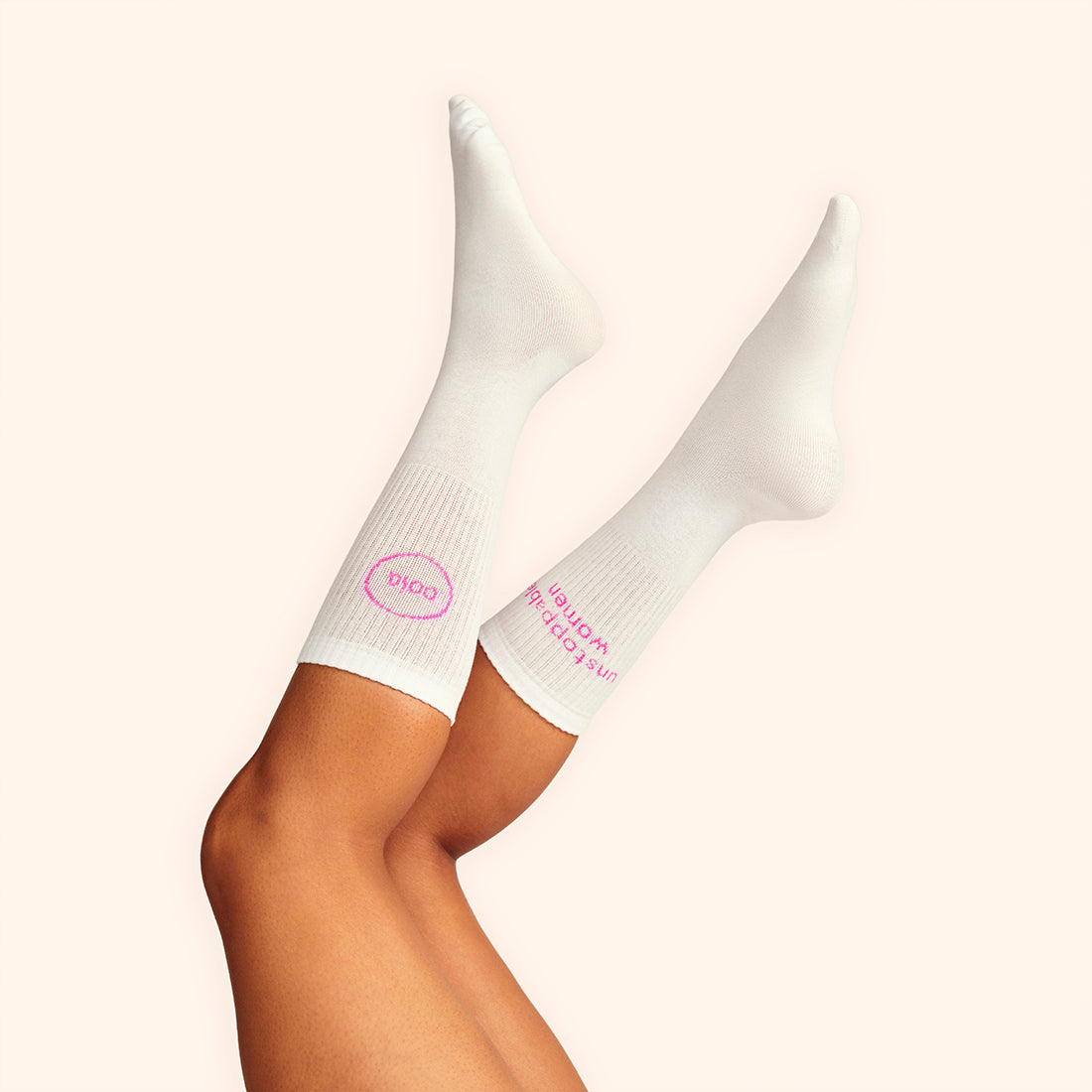 Modell trägt weiße wadenhohe ooia Socken mit dem pinken Aufdruck: Unstoppable Woman