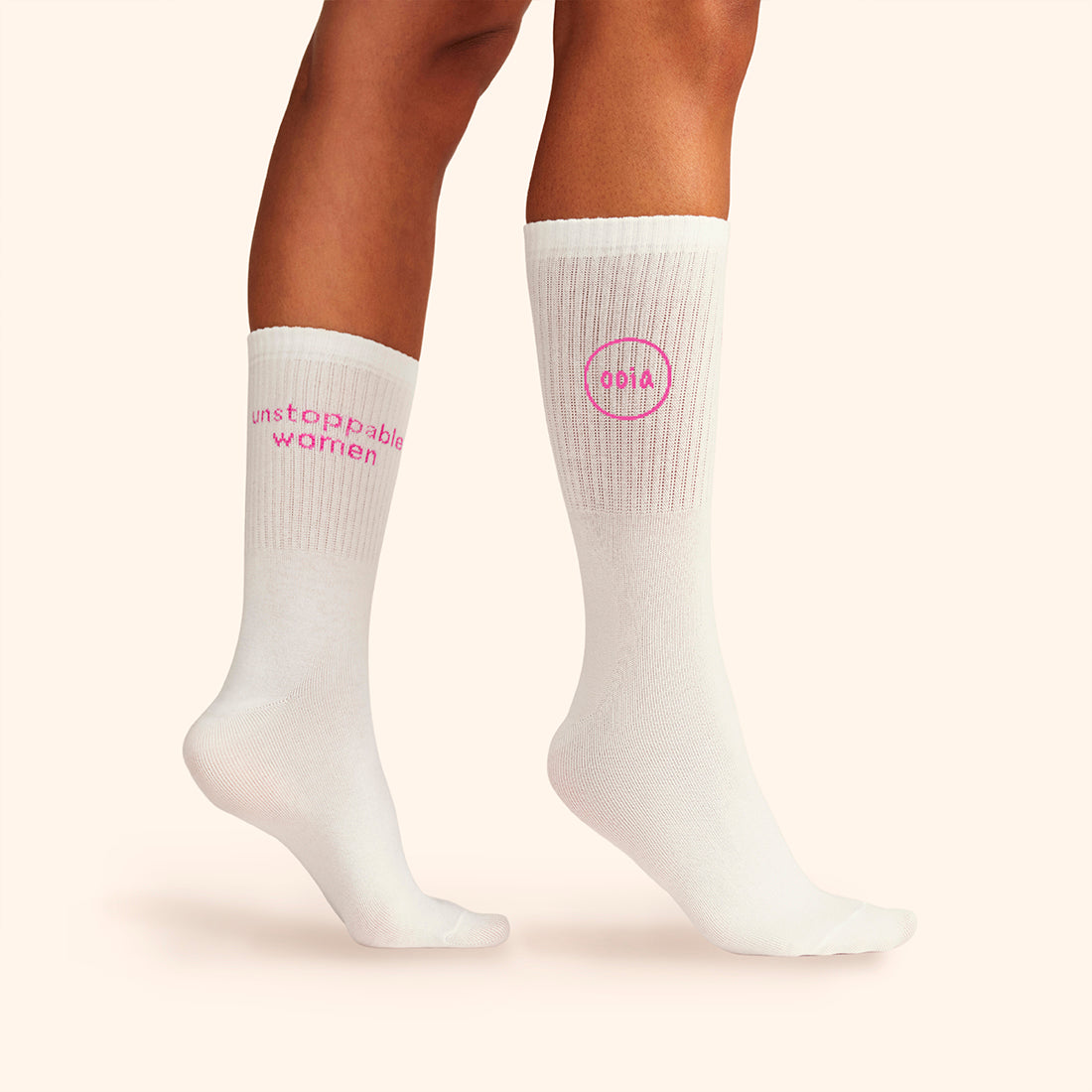Modell trägt weiße wadenhohe ooia Socken mit dem pinken Aufdruck: Unstoppable Woman
