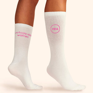 Modell trägt weiße wadenhohe ooia Socken mit dem pinken Aufdruck: Unstoppable Woman