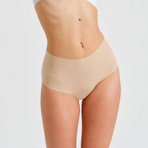 Modell trägt ooia everyday Highwaist Seamless in Beige – nahtlose Unterwäsche mit hohem Bund, die Slipeinlagen ersetzt