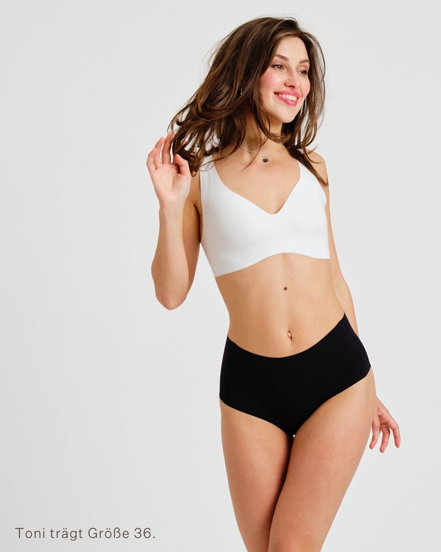 Modell trägt ooia everyday Highwaist Seamless in Schwarz – nahtlose Unterwäsche mit hohem Bund, die Slipeinlagen ersetzt