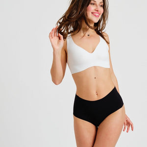 Modell trägt ooia everyday Highwaist Seamless in Schwarz – nahtlose Unterwäsche mit hohem Bund, die Slipeinlagen ersetzt
