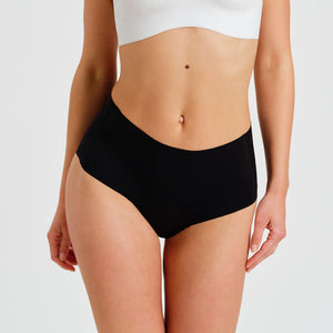 Modell trägt ooia everyday Highwaist Seamless in Schwarz – nahtlose Unterwäsche mit hohem Bund, die Slipeinlagen ersetzt