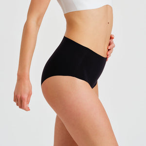 Modell trägt ooia everyday Highwaist Seamless in Schwarz – nahtlose Unterwäsche mit hohem Bund, die Slipeinlagen ersetzt