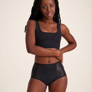 Modell trägt ooia Highwaist Extra Strong in Schwarz – Periodenunterwäsche mit hohem Bund und Glanzdetail.