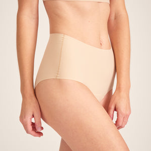 Modell trägt ooia Highwaist Seamless in Beige – nahtlose Periodenunterwäsche mit hohem Bund.
