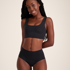 Modell trägt ooia Highwaist Seamless in Schwarz – nahtlose Periodenunterwäsche mit hohem Bund.