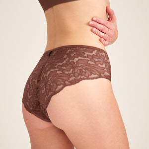 Modell trägt ooia Hipster Allover Lace in Braun – elegante Periodenunterwäsche mit durchgehender Spitze.