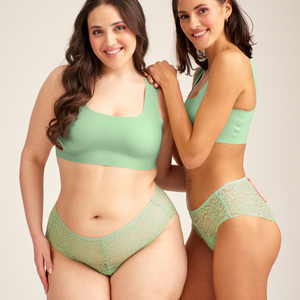 Zwei Models unterschiedlicher Konfektion ooia Hipster Allover Lace in Bright Sage – Periodenslip mit durchgehender floraler Spitze