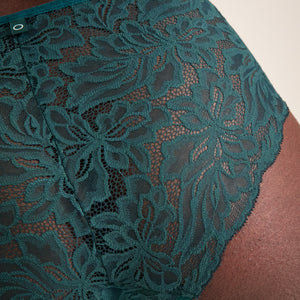Modell trägt ooia Hipster Allover Lace in Grün – elegante Periodenunterwäsche mit durchgehender Spitze. Detailansicht.
