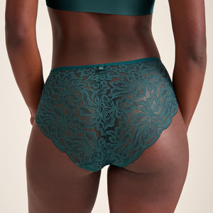 Modell trägt ooia Hipster Allover Lace in Grün – elegante Periodenunterwäsche mit durchgehender Spitze. Rückansicht.