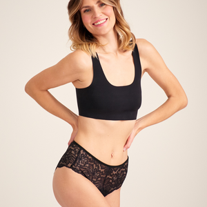 Modell trägt ooia Hipster Allover Lace in Schwarz – elegante Periodenunterwäsche mit durchgehender Spitze.