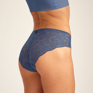 Modell trägt ooia Hipster Allover Lace in Smoky Blue – elegante Periodenunterwäsche mit durchgehender Spitze.