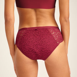 Modell trägt ooia Periodenunterwäsche Hipster Allover Lace in Merlot, mit extra starker Saugstärke und durchgehender Spitze. Rückansicht.