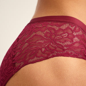 Modell trägt ooia Periodenunterwäsche Hipster Allover Lace in Merlot, mit extra starker Saugstärke und durchgehender Spitze. Detailaufnahme Spitze.