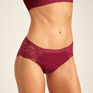 Modell trägt ooia Periodenunterwäsche Hipster Allover Lace in Merlot, mit extra starker Saugstärke und durchgehender Spitze.