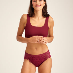 Modell trägt ooia Periodenunterwäsche Hipster Allover Lace in Merlot, mit extra starker Saugstärke und durchgehender Spitze.