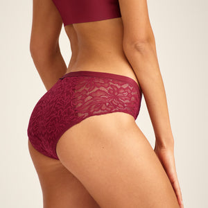 Modell trägt ooia Periodenunterwäsche Hipster Allover Lace in Merlot, mit extra starker Saugstärke und durchgehender Spitze.