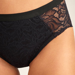 Modell trägt ooia Hipster Allover Lace Extra Strong in Schwarz - Periodenunterwäsche mit durchgehender Spitze und starker Saugstärke. Detailansicht.