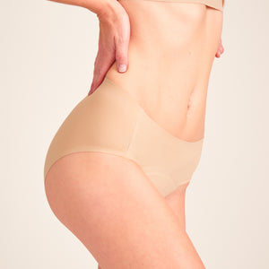 Modell trägt ooia Hipster Seamless in Beige – nahtlose Periodenunterwäsche.