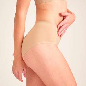 Modell trägt ooia Hipster Seamless in Beige – nahtlose Periodenunterwäsche.