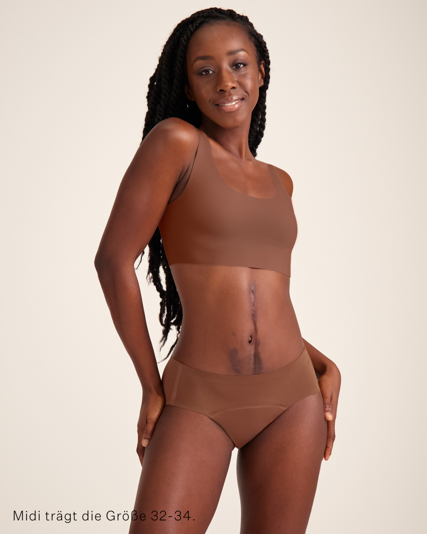 Modell trägt ooia Hipster Seamless in Braun – nahtlose Periodenunterwäsche.