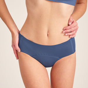 Modell trägt ooia Hipster Seamless in Smoky Blue – nahtlose Periodenunterwäsche.