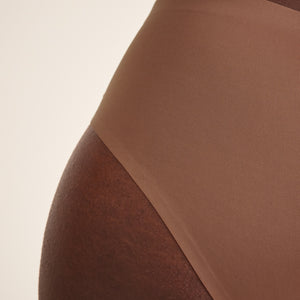Modell trägt ooia Hipster Seamless in Braun – nahtlose Periodenunterwäsche. Detailansicht.
