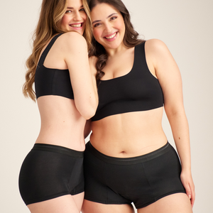Zwei Models unterschiedlicher Konfektionen tragen ooia Shorty Extra Strong in Schwarz – Periodenunterwäsche mit breitem Bund und starker Saugstärke.