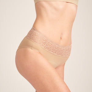 Modell trägt ooia Slip in Beige - Periodenunterwäsche mit breitem Spitzenbund im klassischen Schnitt.
