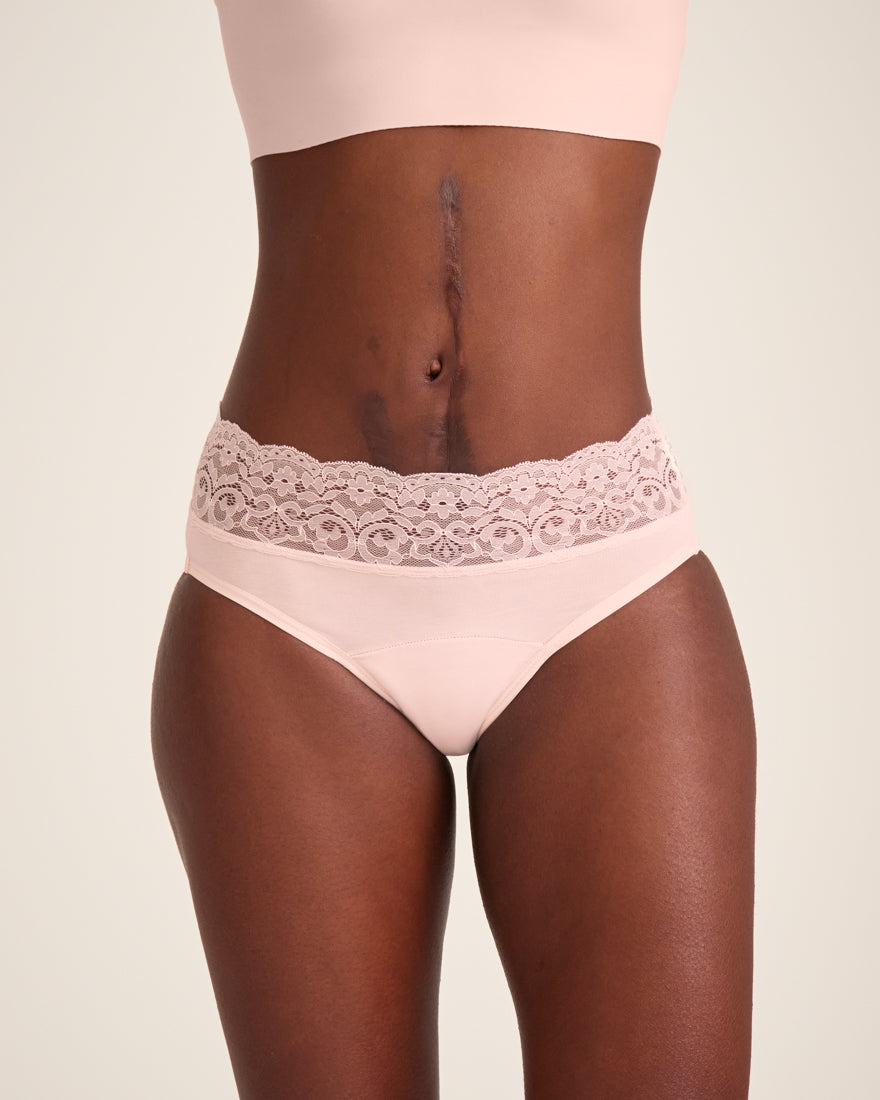 Modell trägt ooia Slip in Powder Rose - Periodenunterwäsche mit breitem Spitzenbund.