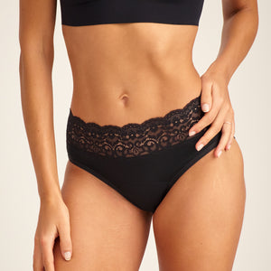 Modell trägt ooia Slip Extra Strong in Schwarz – Periodenunterwäsche mit breitem Spitzenbund im klassischen Schnitt.