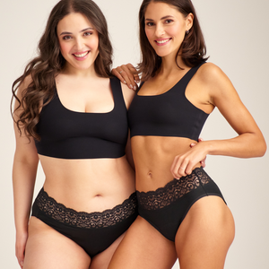 Zwei Models unterschiedlicher Konfektion tragen ooia Slip Extra Strong in Schwarz – Periodenunterwäsche mit breitem Spitzenbund im klassischen Schnitt.