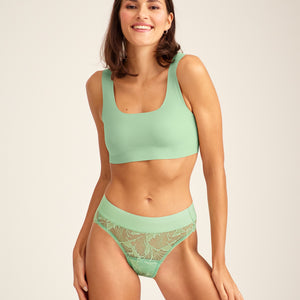 Modell trägt ooia Slip Lace Leaf in bright sage - Periodenunterwäsche mit durchgehender Spitze.