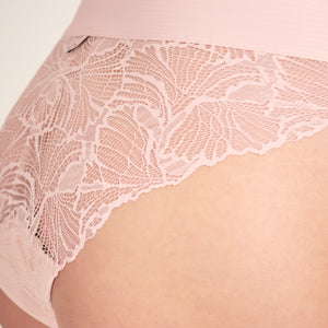 Modell trägt ooia Slip Lace Leaf in Powder Rose – eleganter Periodenslip mit durchgehender Spitze und breitem Bund. Detailansicht