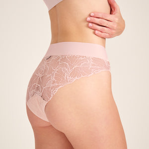 Modell trägt ooia Slip Lace Leaf in Powder Rose – eleganter Periodenslip mit durchgehender Spitze und breitem Bund.