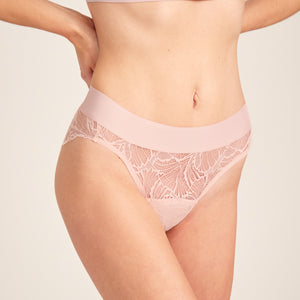 Modell trägt ooia Slip Lace Leaf in Powder Rose – eleganter Periodenslip mit durchgehender Spitze und breitem Bund.