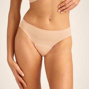 Modell trägt ooia Slip Seamless in Beige – nahtlose Periodenunterwäsche im klassischen Schnitt.