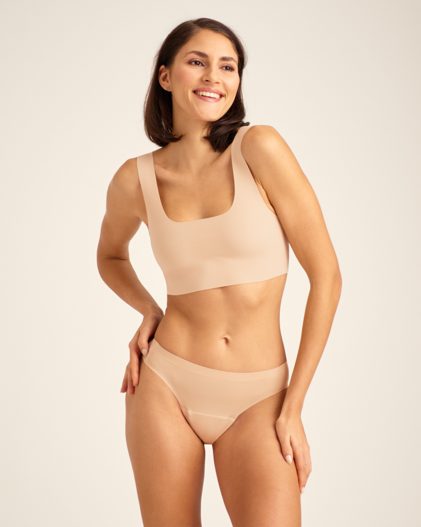 Modell trägt ooia Slip Seamless in Beige – nahtlose Periodenunterwäsche im klassischen Schnitt.