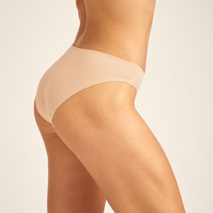 Modell trägt ooia Slip Seamless in Beige – nahtlose Periodenunterwäsche im klassischen Schnitt.