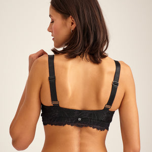 Modell trägt ooia Moms Still-BH Lace in Schwarz – eleganter Still-BH, der Stilleinlagen ersetzt. Rückansicht.