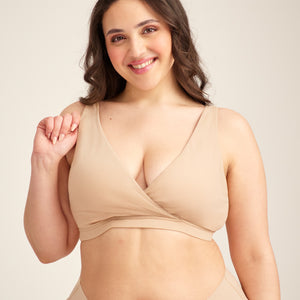 Modell trägt ooia Moms Still-BH in Beige – Still-BH ersetzt Stilleinlagen mit praktischer Pull-Down Funktion.