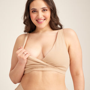 Modell trägt ooia Moms Still-BH in Beige – Still-BH ersetzt Stilleinlagen mit praktischer Pull-Down Funktion. Model demonstriert Pull-Down Funktion.