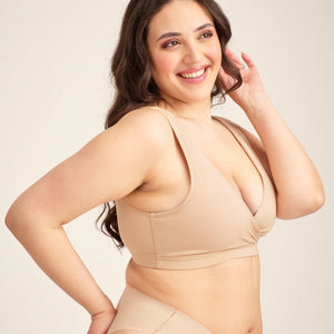 Modell trägt ooia Moms Still-BH in Beige – Still-BH ersetzt Stilleinlagen mit praktischer Pull-Down Funktion.