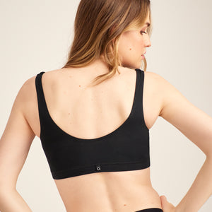 Modell trägt ooia Moms Still-BH in Schwarz – Still-BH ersetzt Stilleinlagen mit praktischer Pull-Down Funktion. Rückansicht.